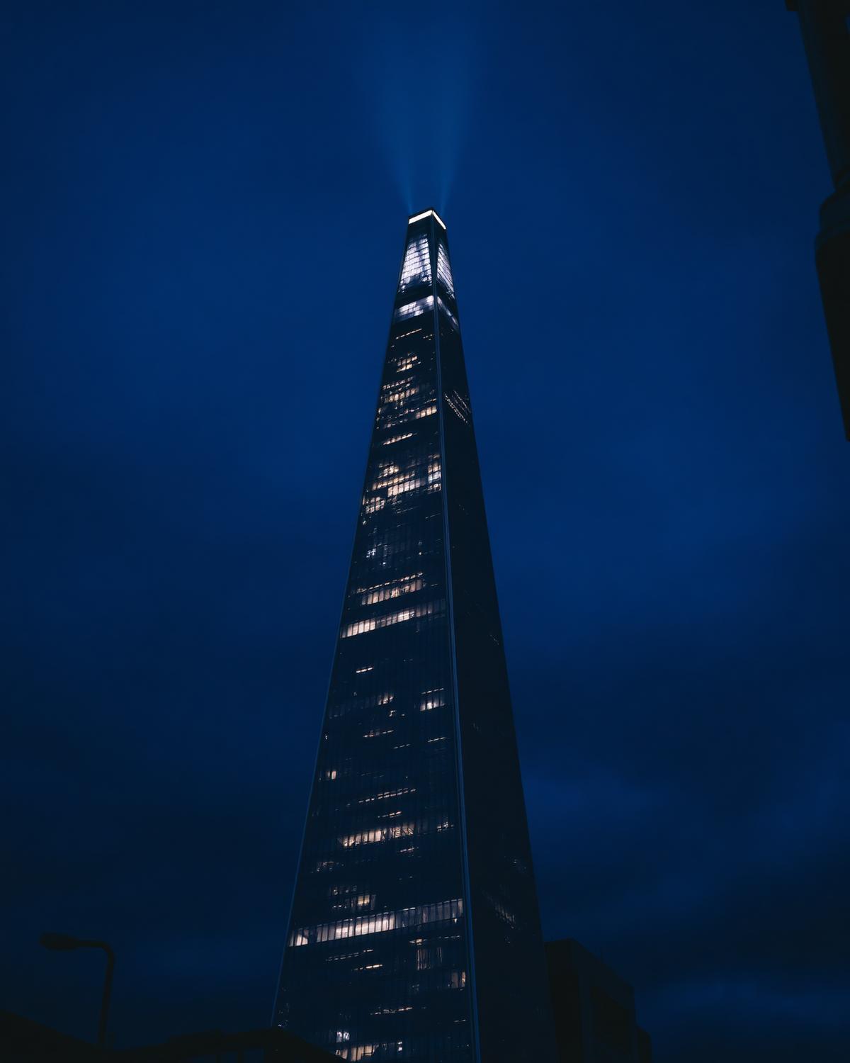The Shard skyscraper lit against a deep blue evening sky in London